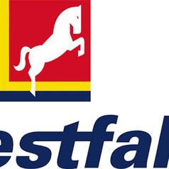 Logo mit einem aufrechten weißen Pferd auf rotem Hintergrund und dem Schriftzug „Westfalen“ in blauer Schrift.