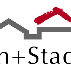 Logo von Wohn+Stadtbau mit stilisierten Dächern und einem roten Pinselstrich über dem Schriftzug.